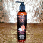 Brown Sugar Luxe handcrafted lotion bottle on a textured surface with a blurred background