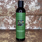 Bottle of Soulful Greens Matcha Bodywash with green label against a textured stone wall background